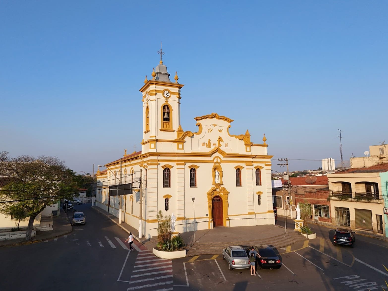 Imagem aérea cinematográfica de igreja na luz dourada captada com drone para produção publicitária